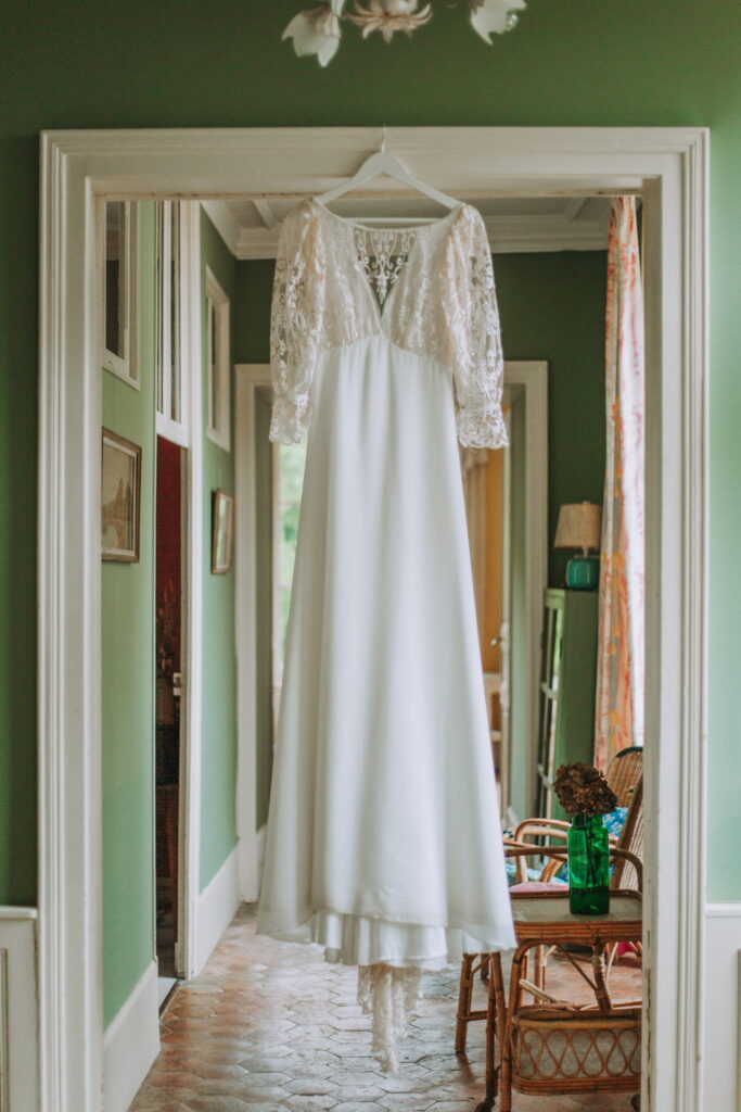 Robe de mariée suspendue dans une maison de campagne à la Villa Augustine